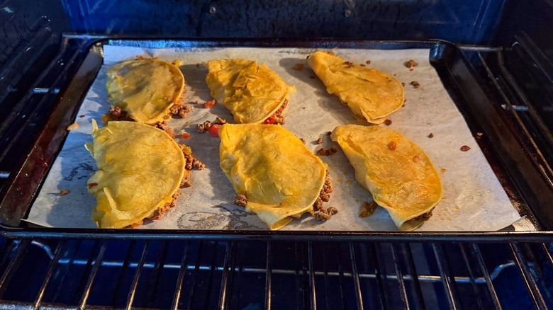 Baked crispy beef tacos on sheet pan in oven