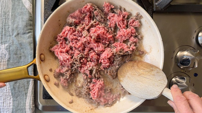 Browning ground beef in skillet on stovetop