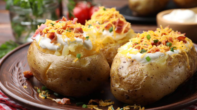 Plate of baked potatoes with cheese and bacon bits