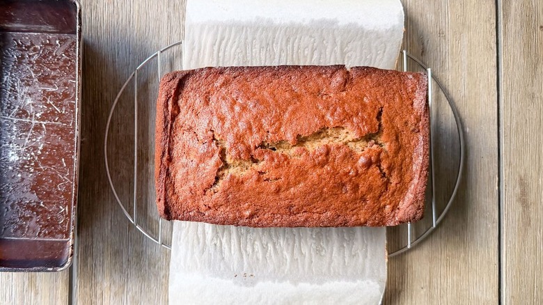 Bakery-worthy banana bread cooling on parchment liner on rack