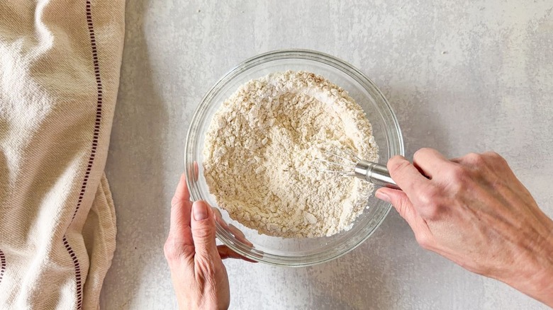 Whisking together flour and other dry ingredients in glass bowl