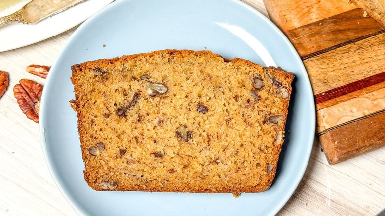 Bakery-worthy banana bread with pecans slice on blue plate