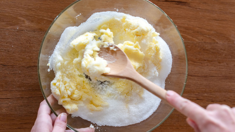 Person blending butter and sugar together