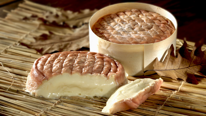 &Eacute;poisses cheese on a wooden surface.