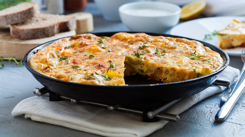 A whole frittata dish with a side of bread