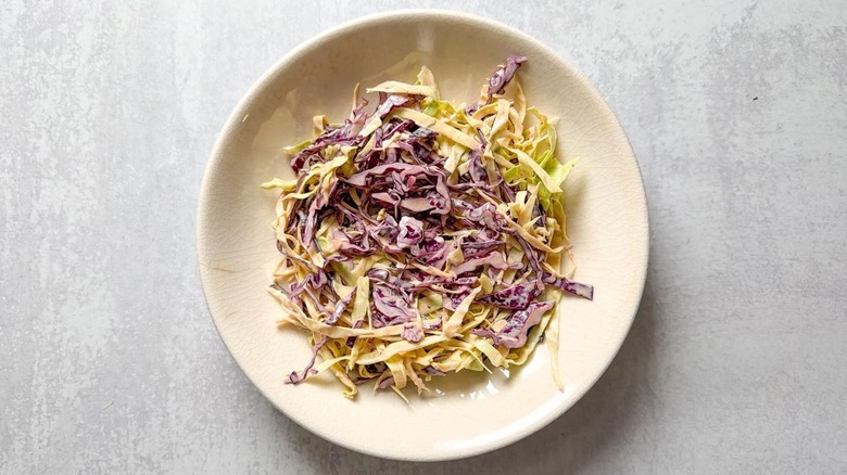 Purple and green cabbage slaw in serving bowl