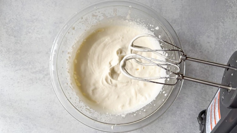 Heavy cream in glass bowl beaten to soft peaks with hand mixer