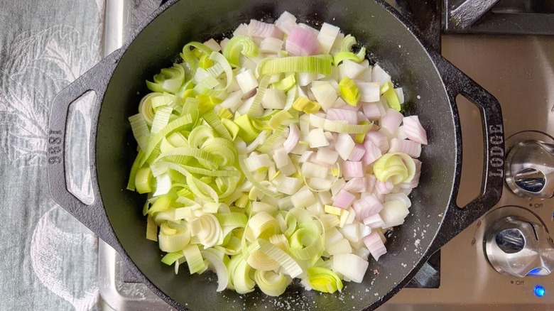 Chopped onion, shallot, and leek in cast iron skillet on stovetop