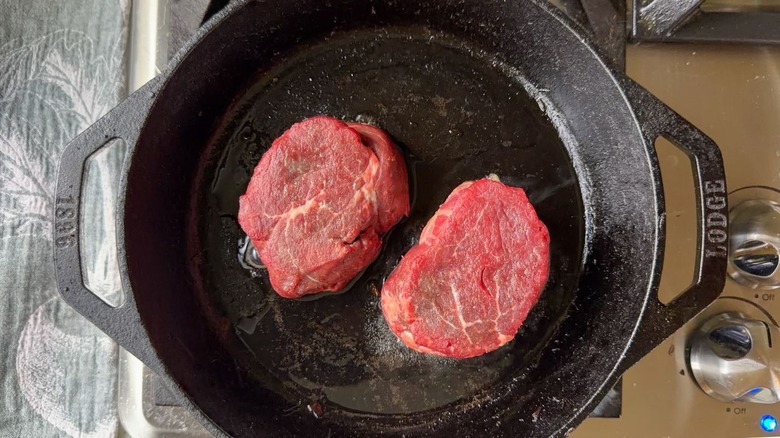 Filet mignon in cast iron skillet on stovetop