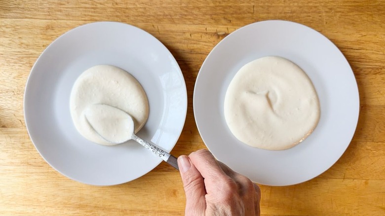 Spreading mustard cream sauce on plates with a spoon