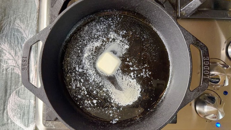 Cast iron skillet with butter and oil on stovetop