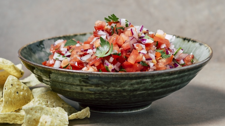 green bowl of salsa with chips