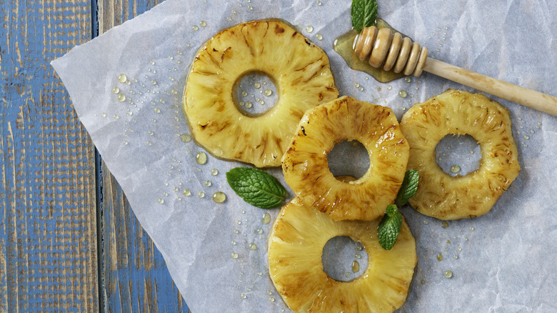 Pineapple slices drizzled with honey and mint leaves