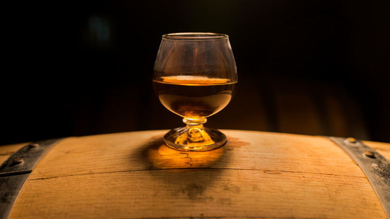 Glass of whiskey on a barrel