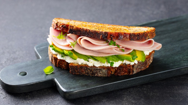 Ham, avocado, sprouts, and soft cheese sandwich on toasted bread
