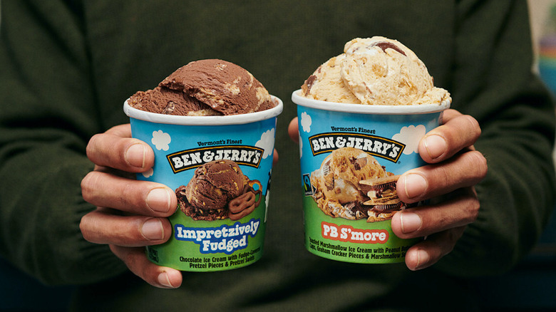 Person holding Ben & Jerry's pint of PB S'more and Impretzively Fudged ice cream.