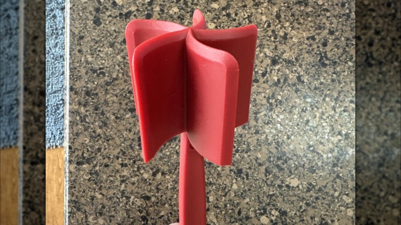 Red meat chopper held above a granite countertop