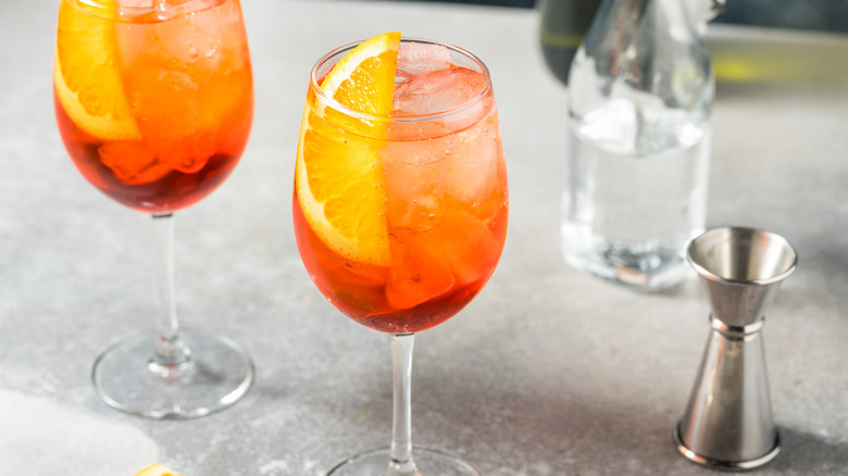 two Aperol spritzes on a gray counter