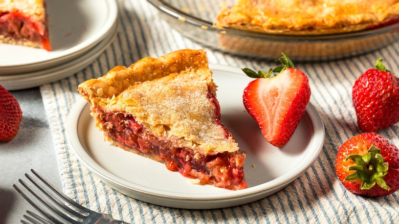 Piece of strawberry pie with a sugar-topped crust on a cream-colored plate