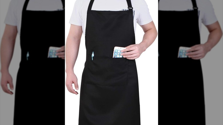 A man wearing a black apron