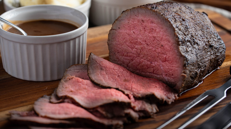 Sliced eye of round roast with side of gravy.