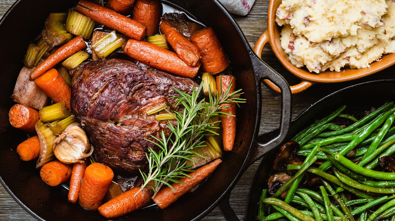 Roast beef in a Dutch oven with vegetables.