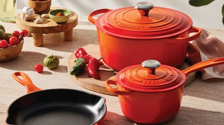 Orange Le Creuset Set on a counter with vegetables