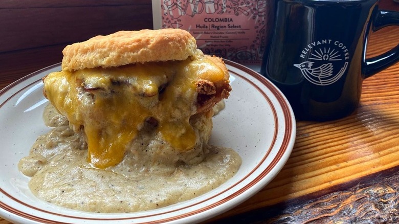 A bsicuit sandwich with gravy on a plate at Pine State Biscuits