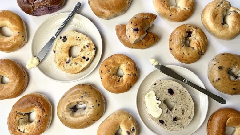 a variety of blueberry bagels, some toasted with butter