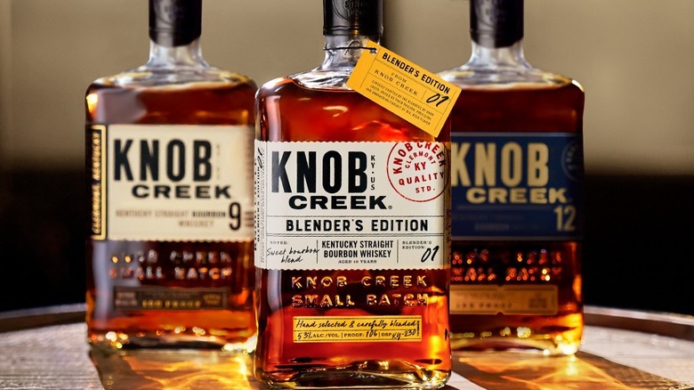 Bottles of Knob Creek bourbon on a wooden barrel