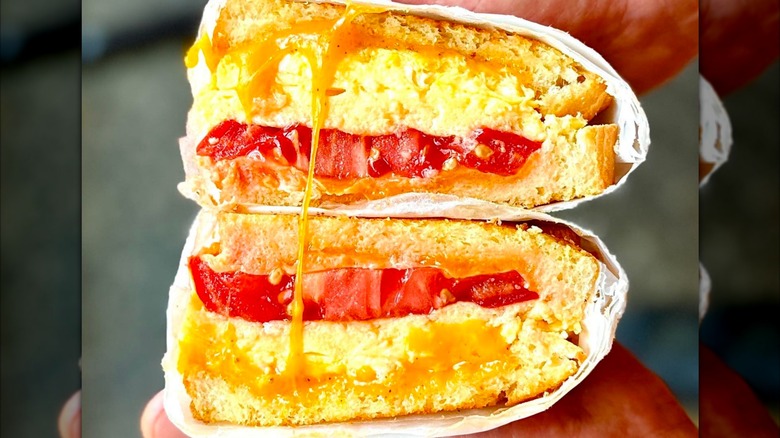 A person holding the All-day Egg & Cheese Sandwich at Kitchen Table in Omaha