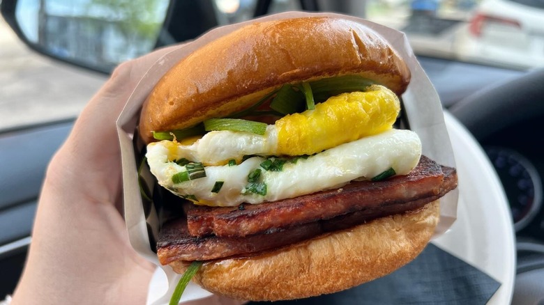 A person holding a Porter breakfast sandwich at Cackleberry in Cincinnati