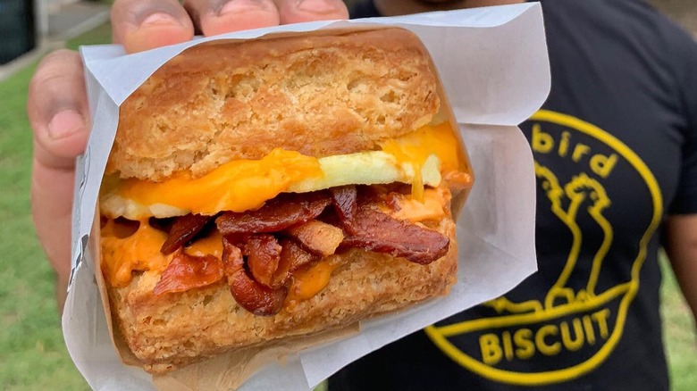 A person holding a Bird Bird Bacon sandwich at Bird Bird Biscuit in Austin
