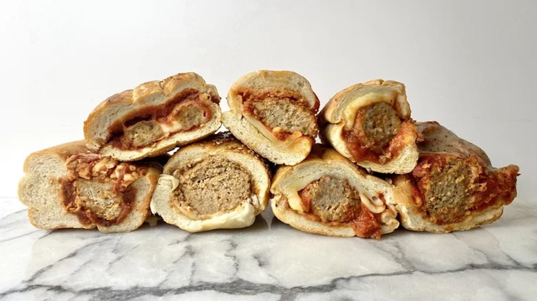 Several meatball subs from various chain restaurants are arranged together.