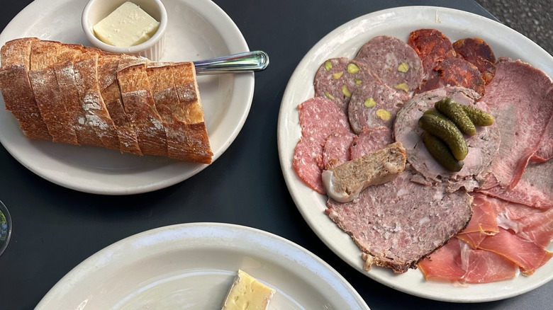 Plates of bread with butter, charcuterie, and cheese at Le Pichet
