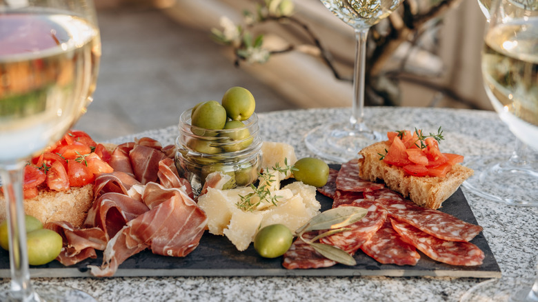 A charcuterie board on a table with wine at a restaurant