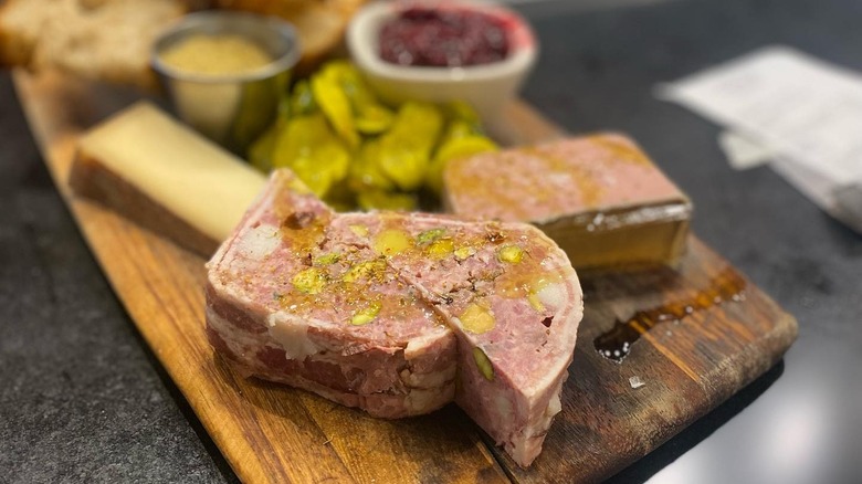 Pork pate with cheese, pickles, and condiments on a charcuterie board at The Salty Pig
