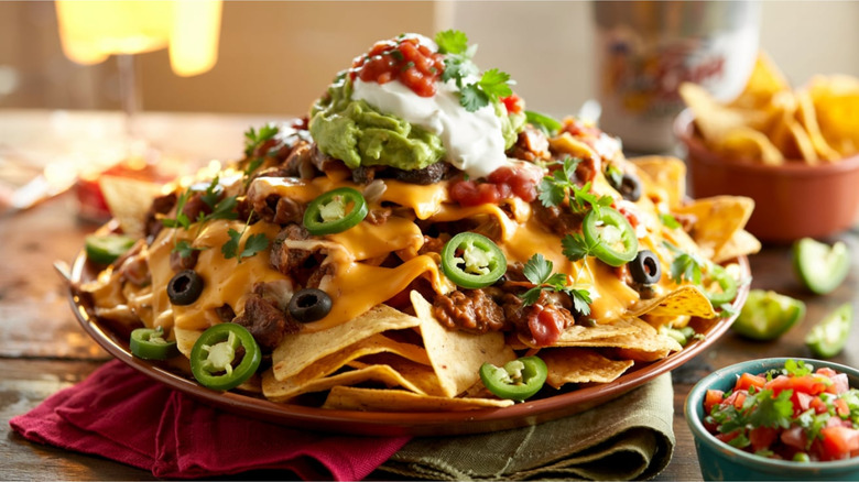 Piled-high nachos with jalapeños, salsa, and guacamole