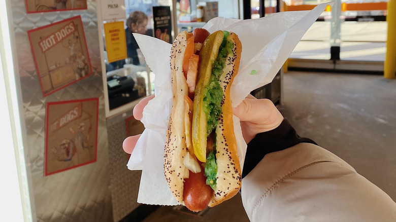 A person holding a Fixin' Franks hot dog