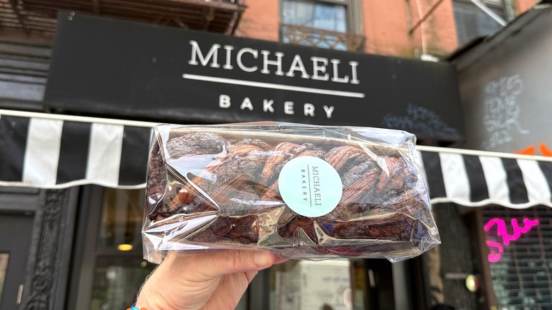 a babka held high in front of Michaeli Bakery