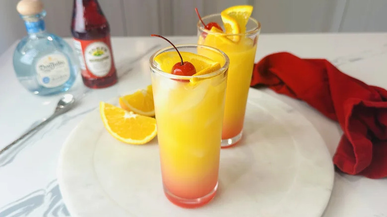 Two glasses of tequila sunrise on a white plate