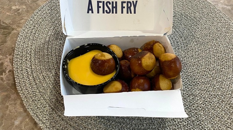 Culver's pretzel bites on a table with one in cheese sauce