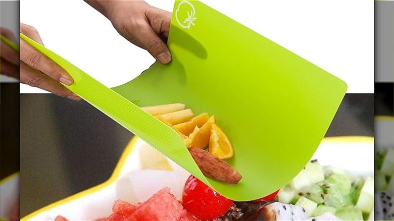A green flexible cutting mat with food