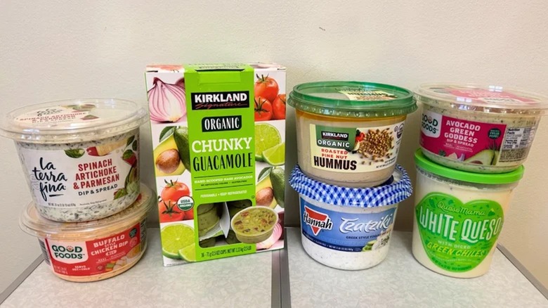 A variety of dip options from Costco sitting atop a white table