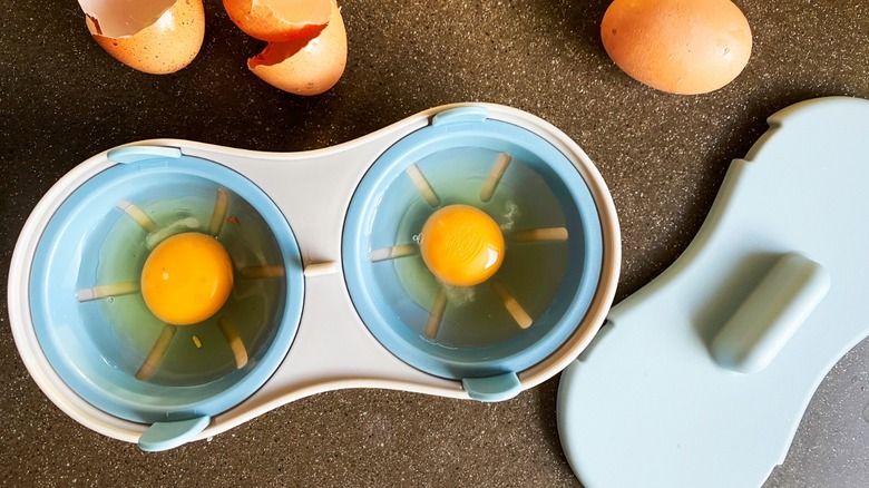raw eggs inside a microwave egg poacher