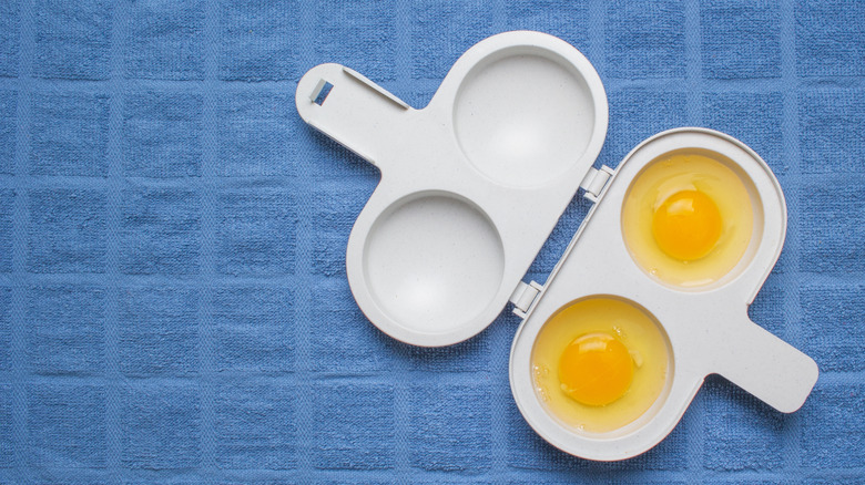 two raw eggs in a microwave poacher