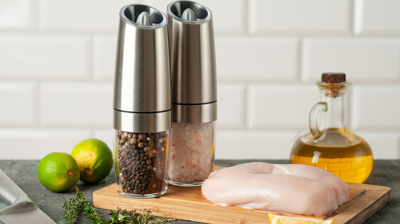Electric salt and pepper mills on cutting board