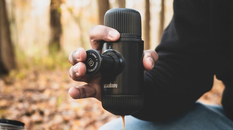 Man using Wacaco Nanopresso pulling espresso outdoors