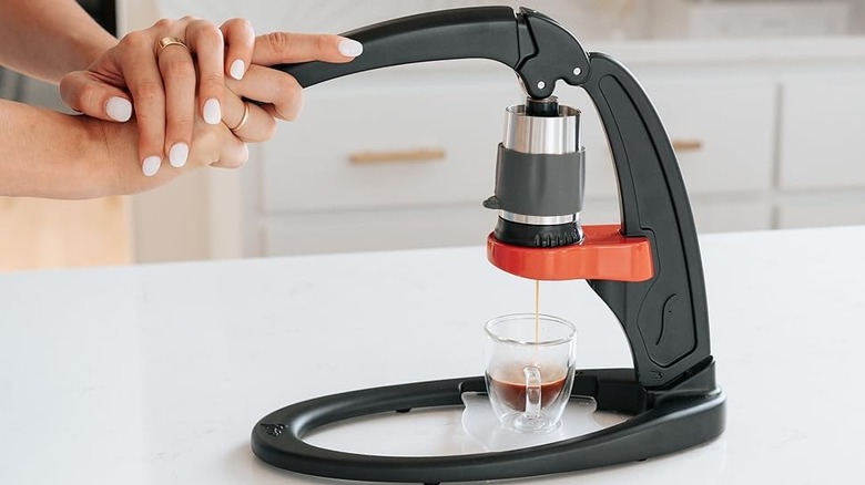 Woman using Flair Espresso Maker on kitchen countertop