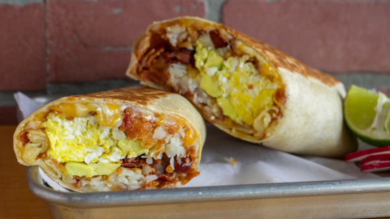 A breakfast burrito with a lime wedge